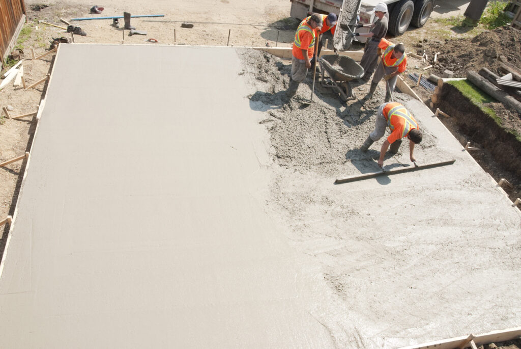 professionals laying concrete garage pad