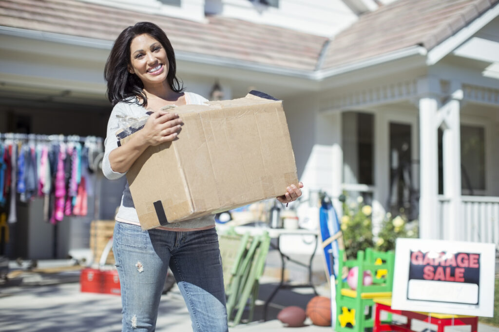 woman holding-box-having-garage-sale