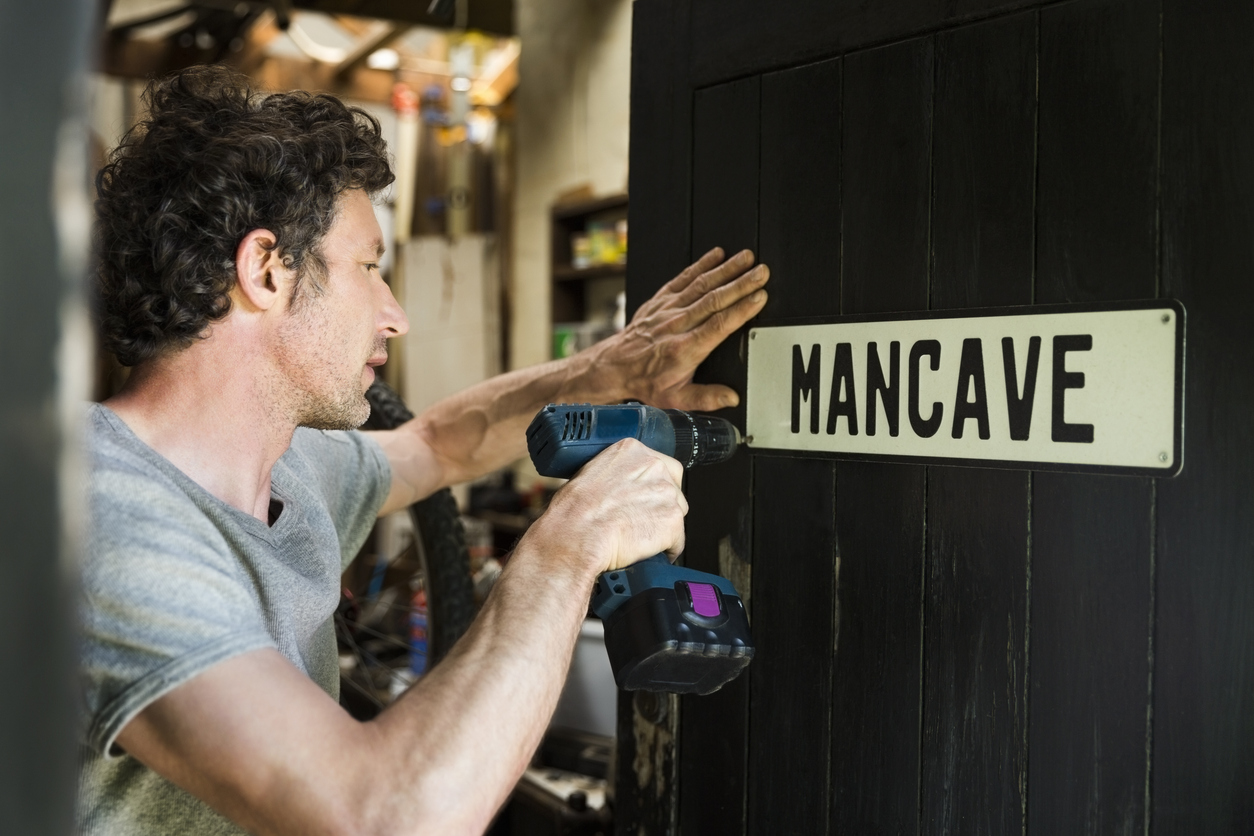 man-hanging-sign-on--door-of-mancave
